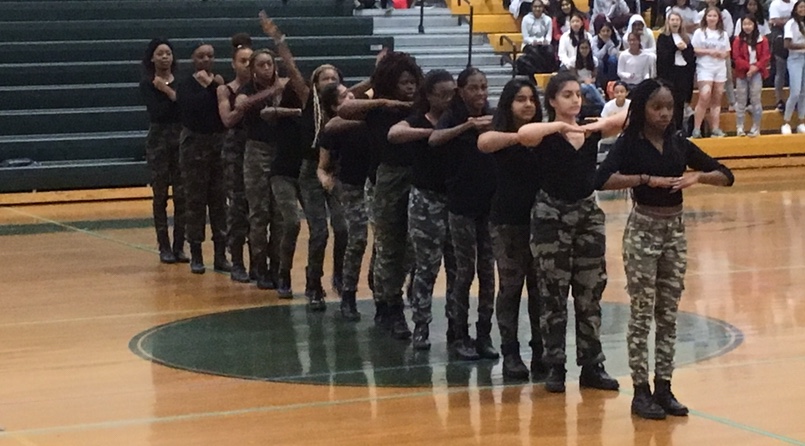 The Step Team stomps and claps to a rhythmic sequence at the fall gym rally. 