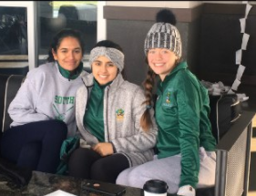 Isabella McCloskey (right), sits with her senior friends on the golf team, Vrinda Attri (center), and Shreya Hariharan (left), on a chilly day. 