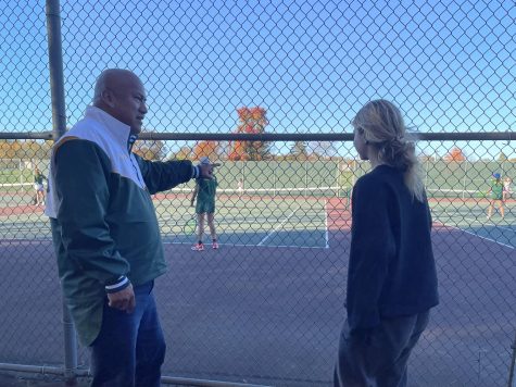 Coach Valenzuela talks to team manager Isabella Colitsas (23) while his team takes on Princeton high schools girls tennis team.